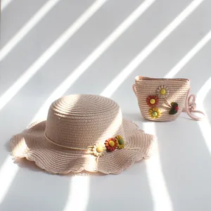 Détail d'un chapeau de paille pour filles avec sac assorti et fleurs au soleil