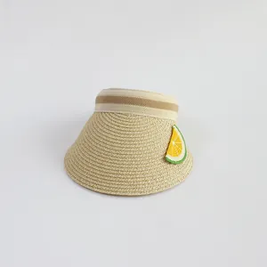 Detail of woven straw sun hat featuring a striped band and crochet lemon patch