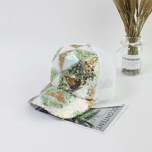 Detail of sequin baseball cap with green, gold, and silver geometric pattern on white mesh
