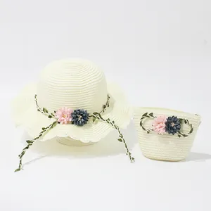 Detail of hand-woven straw sun hat and matching floral bag set with wavy brim