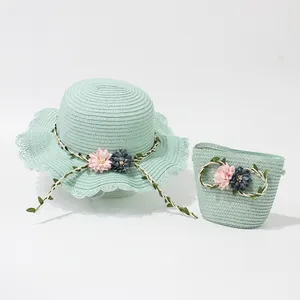 Detail of mint green woven straw hat and matching bag with decorative floral accents