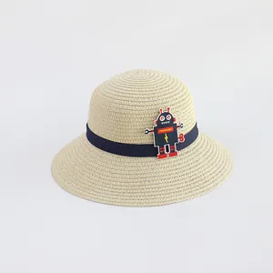 Dettaglio della trama del cappello di paglia beige con nastro blu e patch robot