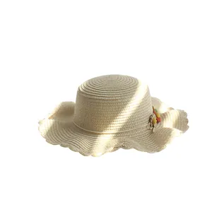 Chapeau de paille pour enfant avec fleurs décoratives et bord ondulé élégant