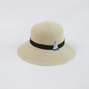 Dettaglio ravvicinato del cappello di paglia con nastro nero e ricamo a barca