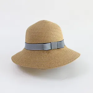 Detailed close-up of handmade woven straw hat with blue white striped ribbon and bow