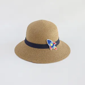 Dettaglio cappello in paglia per bambini con nastro blu e toppa a forma di razzo