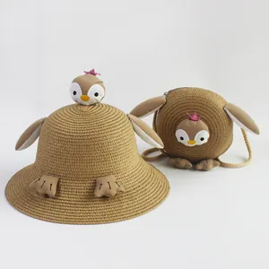 Detalle de sombrero de paja para niños y bolso a juego con diseño de pingüino animado