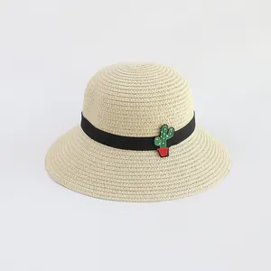 Dettaglio del cappello di paglia con trama intrecciata e ricamo di cactus sul nastro