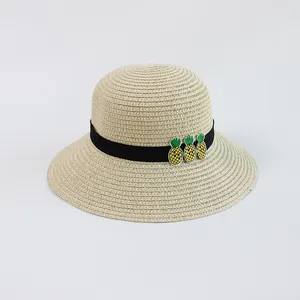 Dettaglio cappello di paglia beige con nastro nero e ricamo di ananas