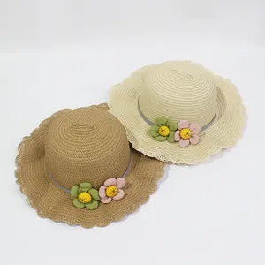 Kids woven straw sun hats with wavy brims and floral decor in beige and khaki colors