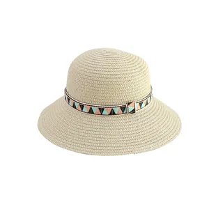 Children's summer woven straw sun hat with geometric patterned ribbon strap on white background
