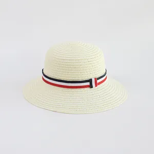 Dettaglio di cappello in paglia beige con nastro a righe rosso bianco e blu in stile classico