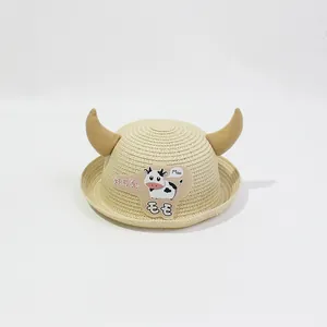 Détail de la paille tressée et patch de vache sur ce chapeau d'été enfant