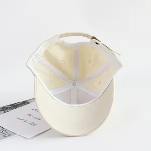 Interior view of beige cotton kids baseball cap with adjustable metal buckle strap