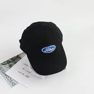 Detailed close-up of a black cotton baseball cap with a blue embroidered oval patch
