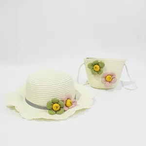 Detail of straw hat and matching bag set with wavy brim and floral decorations