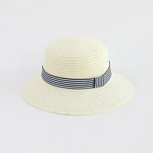 Dettaglio della trama intrecciata e del nastro a righe blu su un cappello di paglia beige