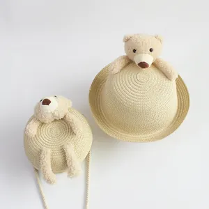 Detail of children's straw hat and matching bag with cute plush bear decorations