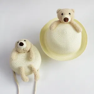 Detail of kids straw sun hat and matching crossbody bag with cute 3D plush bear
