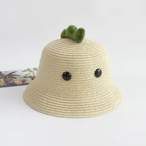 Detalle de sombrero de paja infantil de dinosaurio con espinas de felpa y textura tejida