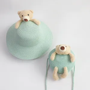 Detail of mint green straw sun hat and matching teddy bear crossbody bag set for kids
