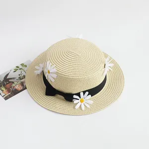Détail de chapeau de paille d'été avec ruban noir et décorations de fleurs de marguerite