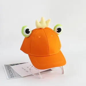 Détail de la casquette grenouille orange pour enfants avec couronne et grands yeux
