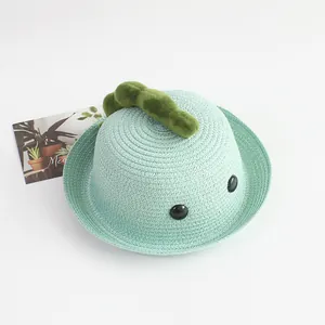 Detalle de sombrero de sol de paja verde menta con lindas espinas de dinosaurio para niños