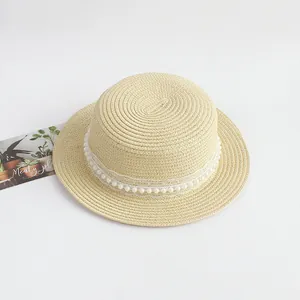 Détail d'un chapeau de paille beige avec dentelle blanche élégante et perles décoratives