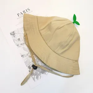 Detail of beige cotton baby bucket hat with green sprout decor and adjustable drawstring