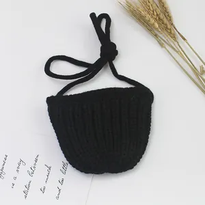 Detailaufnahme der schwarzen handgestrickten Minitasche mit grober Garnstruktur und Gurt