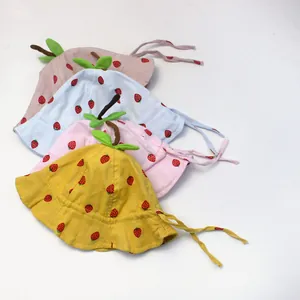 Detail of baby sun hats featuring strawberry prints, 3D leaf stems and chin straps