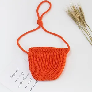 Makro-Detail der leuchtend orangefarbenen Mini-Stricktasche mit strukturierter Wolle