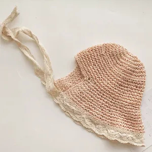 Détail d'un chapeau de paille pour enfant avec dentelle crème et rubans élégants