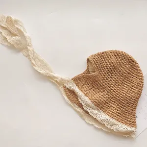 Détail du bonnet en paille pour enfant avec bordure en dentelle et longs rubans à nouer