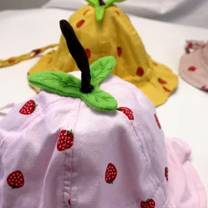 Detail of baby sun hat showing the breathable cotton fabric and 3D strawberry leaf decoration