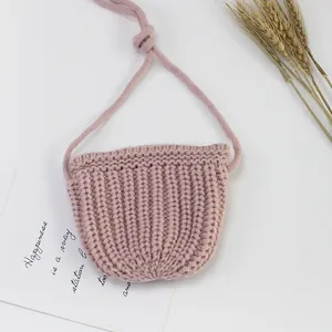 Detaillierte Stricktextur einer kleinen rosa handgefertigten Häkelumhängetasche für Mädchen