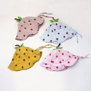 Flat lay of baby sun hats in four colors with strawberry floral pattern and leaf stem