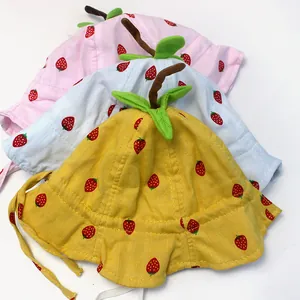 Detail of baby sun hats with strawberry patterns and 3D leaves in yellow, white, and pink