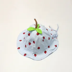 Detail of baby sun hat with strawberry print, green leaf decor and chin strap
