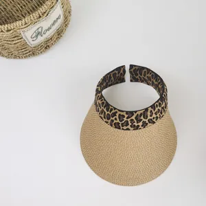 Macro view of woven straw sun hat texture with leopard print trim and floral prop