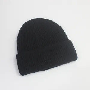 Détail du bonnet en maille noire montrant la texture côtelée et le revers classique