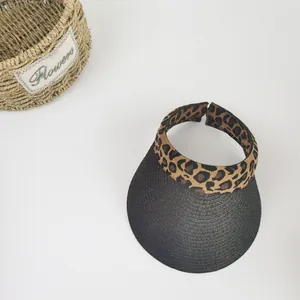 Detail of woven straw sun hat with leopard print headband and breathable black wide brim