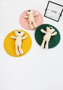 Three children wool berets in pink, yellow and green with cute plush teddy bears on top
