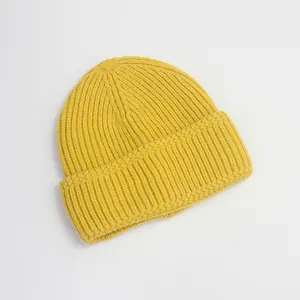 Détail de la texture côtelée du bonnet en tricot jaune pour une chaleur hivernale