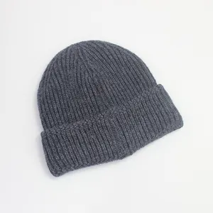 Détail macro du bonnet en maille côtelée gris foncé montrant la texture épaisse