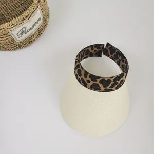 Detail of woven straw sun hat brim with leopard print elastic band for beach vacation