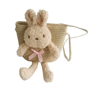 Cute straw crossbody bag for girls featuring a 3D plush bunny doll and a pink ribbon bow