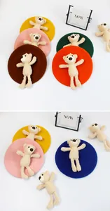 Detailed view of kids wool beret featuring a cute plush teddy bear in vibrant colors