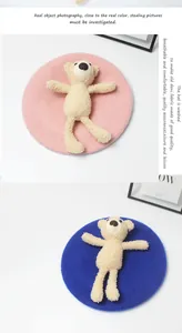 Detailaufnahme von rosa und blauen Wollbaskenmützen mit süßen 3D-Plüschbären-Verzierungen